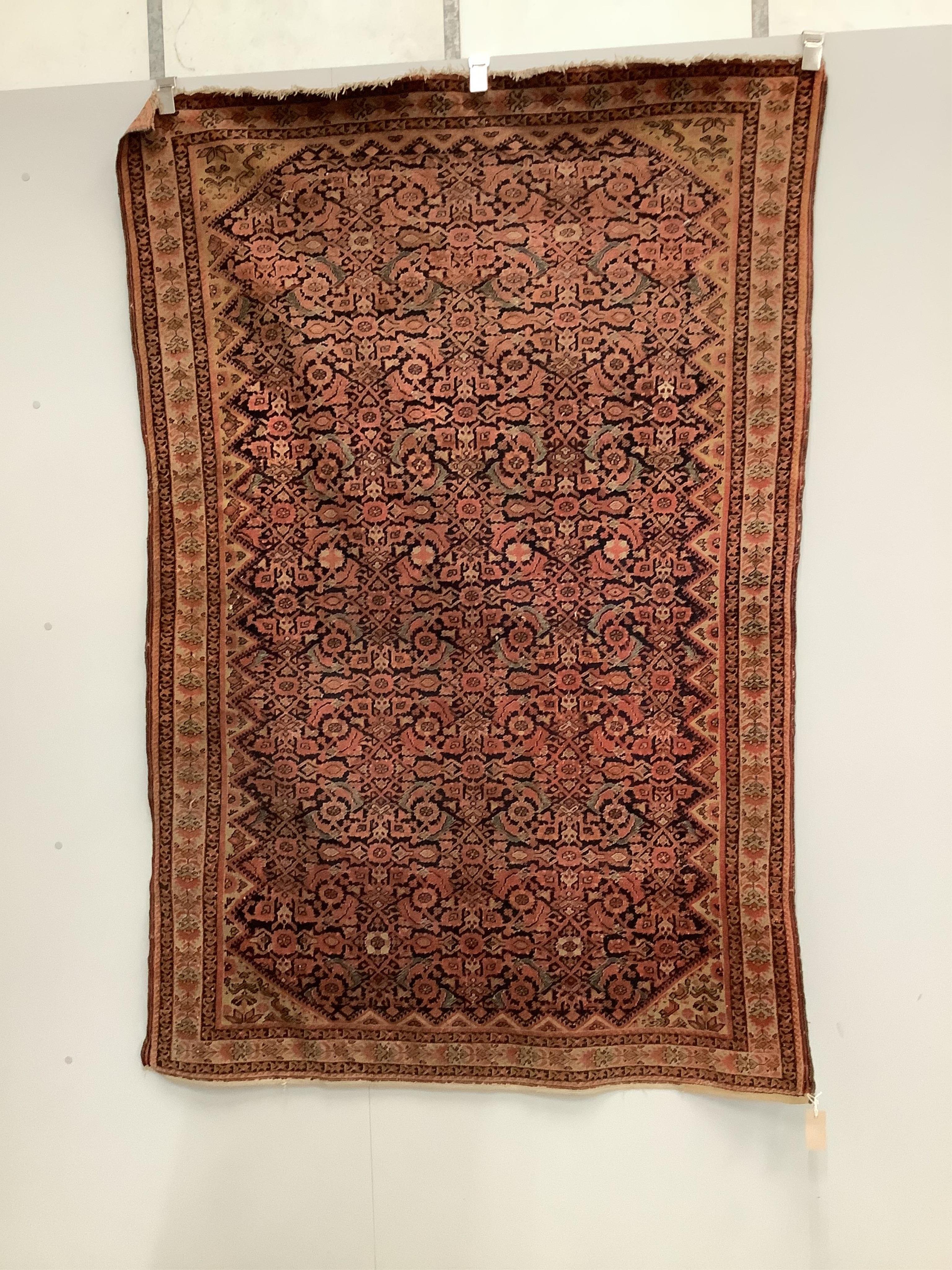 A Caucasian red ground rug, 192 x 129cm. Condition - faded and worn